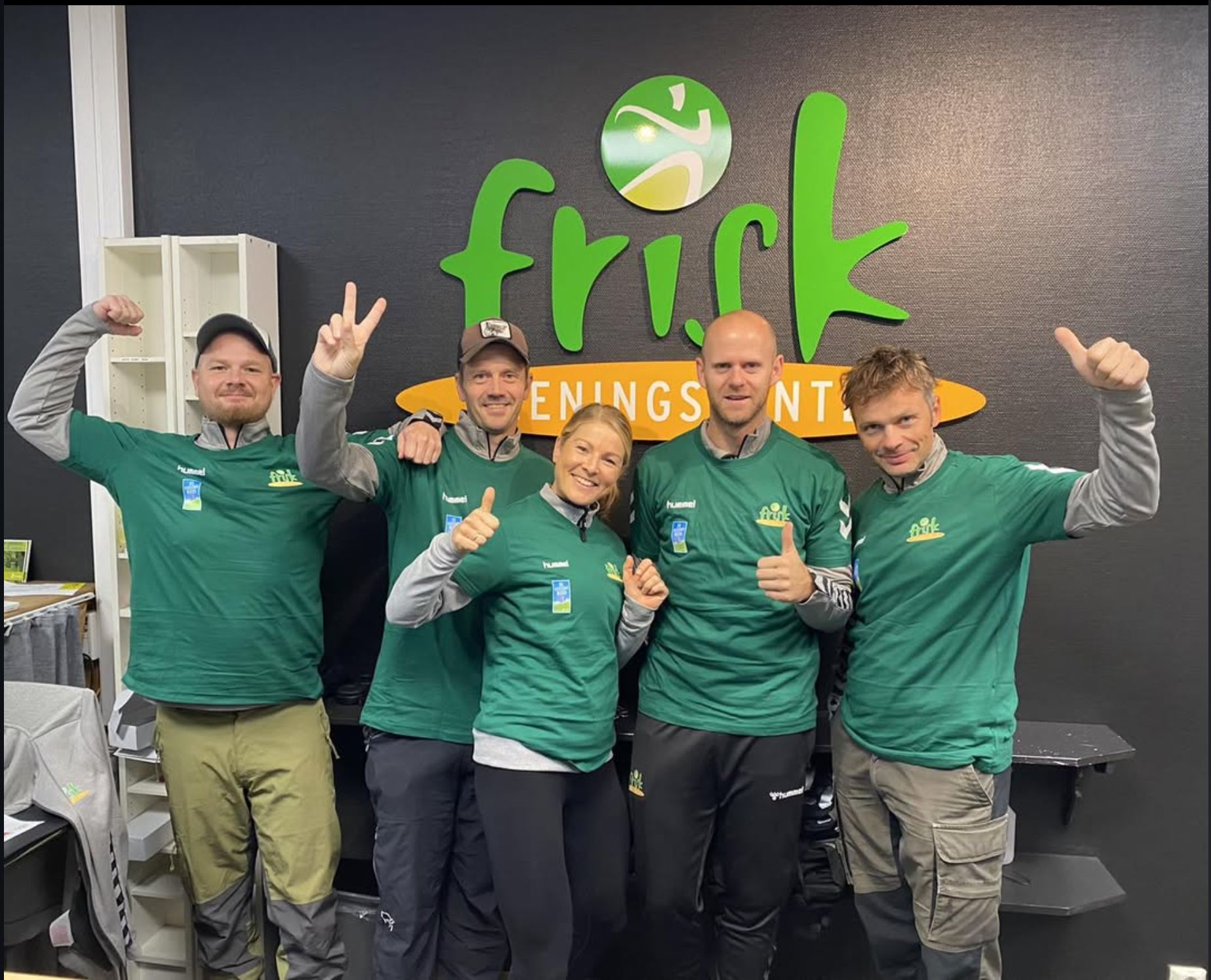 Noen av de ansatte foran Frisk-logoen i resepsjonen